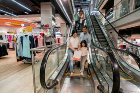 Family walking off escalator at shopping mall