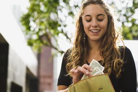 Woman taking cash out of wallet