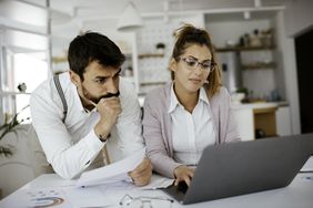 Worried young couple with financial bills review their options