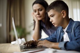 mom and son looking at something on laptop