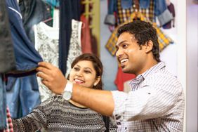 Smiling couple shopping for clothing together