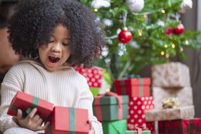 A young child marvels at an opened gift.