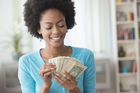 Woman in blue sweater counting cash in her hands